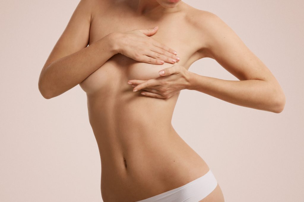 Breast cancer self check, healthy lifestyle concept. Young pretty woman examining her breast for lumps or signs of breast cancer – Alpha Hospital Group