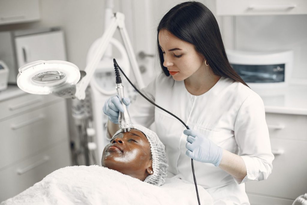 Clinician examining skin before a shave biopsy at Alpha Hospital Group
